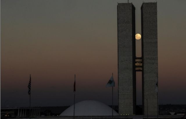 Vista da lua cheia entre as duas torres do prédio do Congresso Nacional, em Brasília, na noite do dia 25
