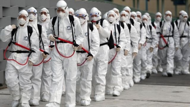 South Korean soldiers wearing protective gear spray disinfectant in Daegu on 19 February 2020