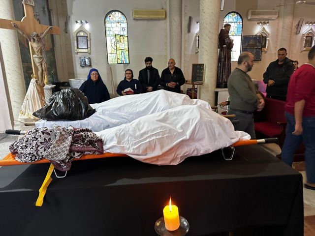 ジャウダトさんの祖母とおばの遺体は白い布でくるまれ、教会に安置された