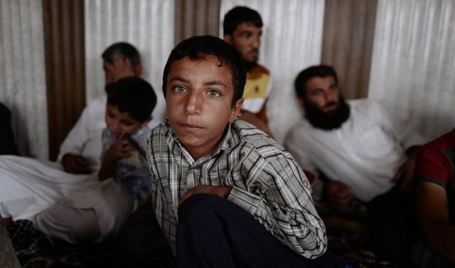 طفل يجلس مع أسرته في غرفة مكتظة بمدنيين في كوكجلي. وفي الوقت الذي كانت فيه قوات الأمن العراقية تنظم حملات في المدينة، كان مسلحو تنظيم الدولة الإسلامية يمنعون المدنيين من المغادرة ويطلقون النار على كل من يسعى لذلك