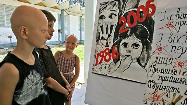 Varios niños miran una ilustración de recuerdo a las víctimas de Chernóbil