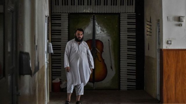 أحد أفراد حركة طالبان يسير في ممر في المعهد الوطني الأفغاني للموسيقى في كابل، 14 سبتمبر/أيلول 2021