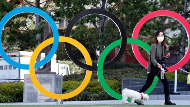 A Japanese woman in front of the Olympic rings