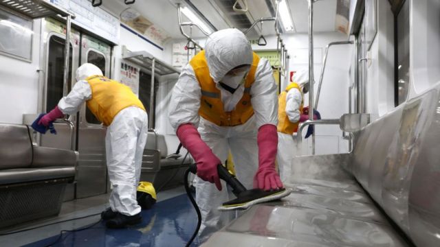 Funcionários limpando metrô na Coreia do Sul usando equipamentos de proteção individual