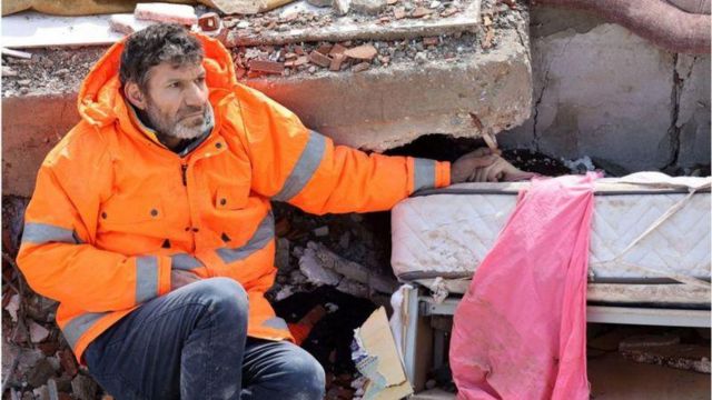 Mesut Hancer segurando a mão da filha morta em meio aos escombros do terremoto