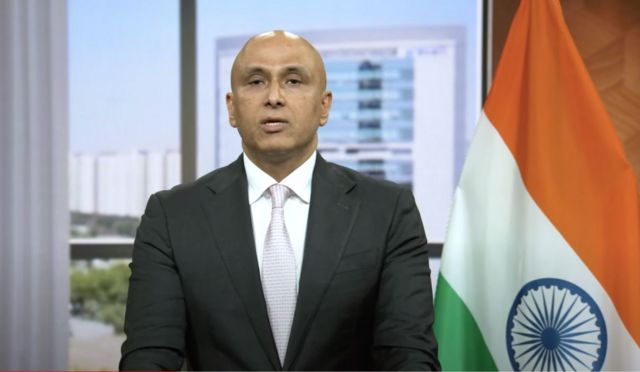 ভারতের পতাকা পেছনে রেখে বিবৃতি দিচ্ছেন আদানি গোষ্ঠীর সিএফও