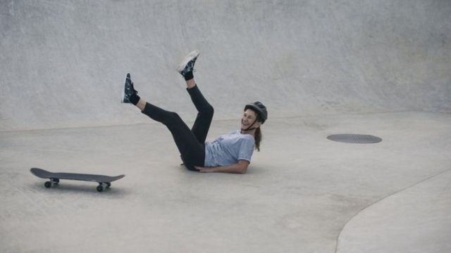 Mulher sorrindo após cair de skate