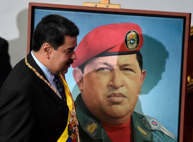 Nicolás Maduro junto a un retrato de Chávez.