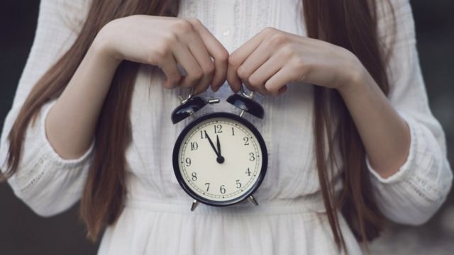 Mujer con un reloj en las manos