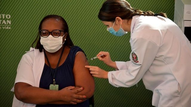 Enfermeira Monica Calazans tomando a primeira dose da CoronaVac