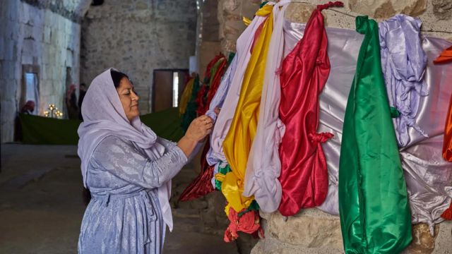 Mulher com véu da nós em lenços de seda dentro de um templo