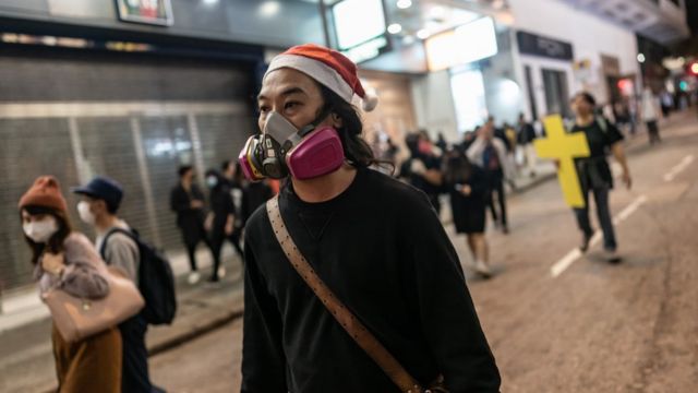 A protester reacts after police fire tear gas to disperse bystanders in a protest in Jordan district in Hong Kong, on early December 25, 2019.