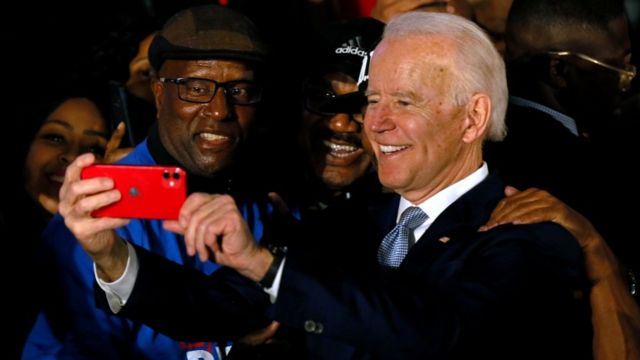 Joe Biden takes a selfie with two voters.