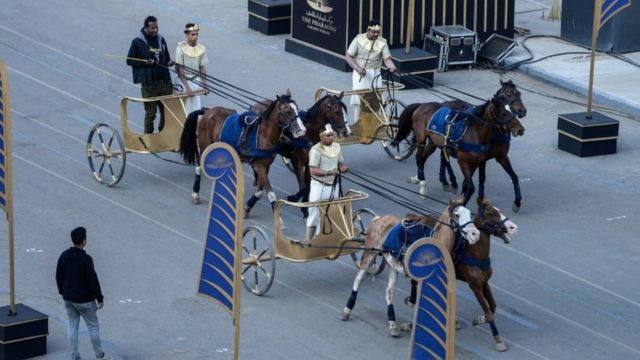 Men dressed up in traditional wear on chariots