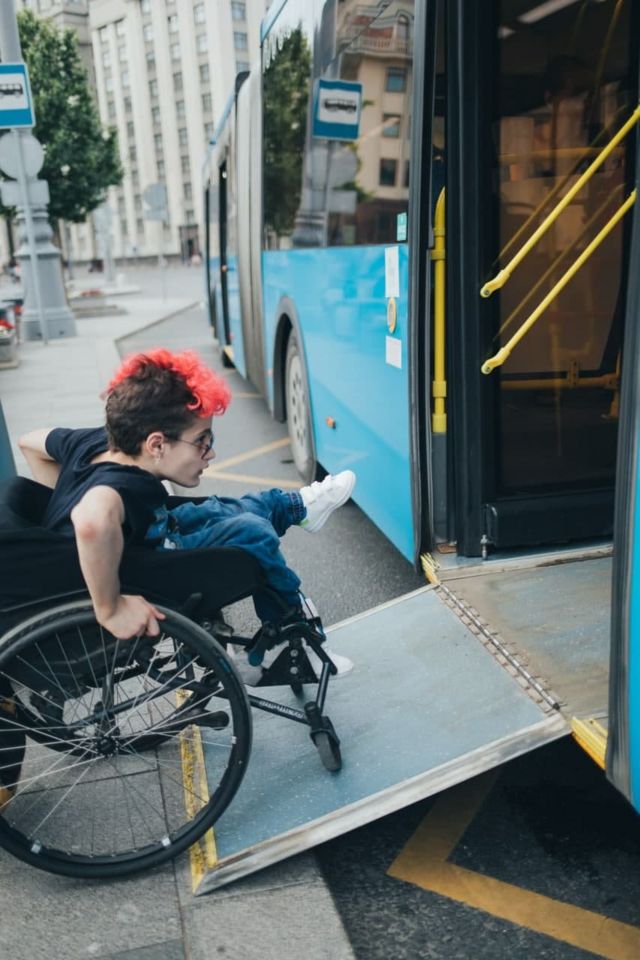 Молодой человек в инвалидном кресле заезжает в автобус в Москве