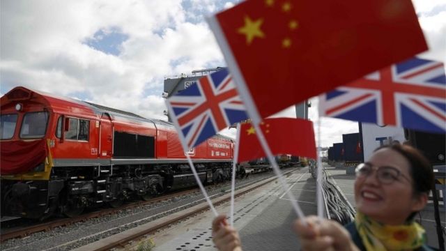 Chinese women wave flages at the official ceremony to mark the departure of the first UK to China export train, laden with containers of British goods, from the DP World London Gateway, Stanford-le-Hope, Britain April 10, 2017.