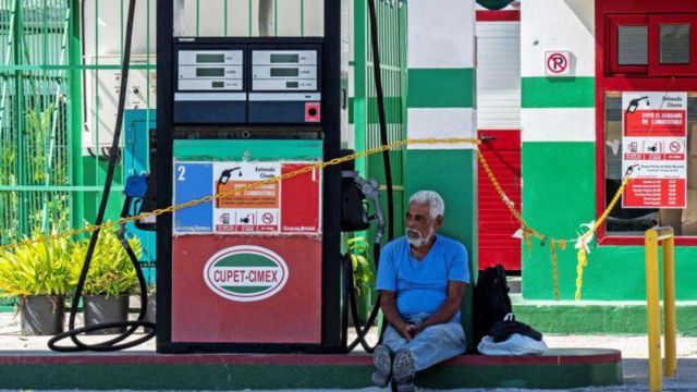 homem em frente a bomba de gasolina