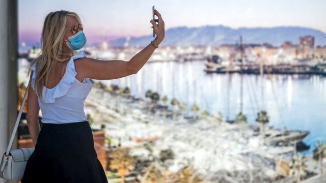 Woman taking a selfie wearing a face mask in Malaga.