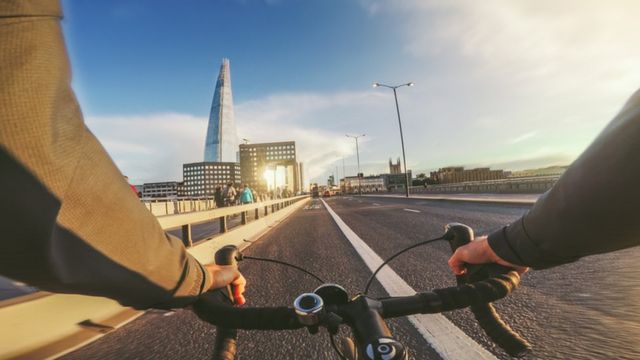 Someone cycling across a bridge in London