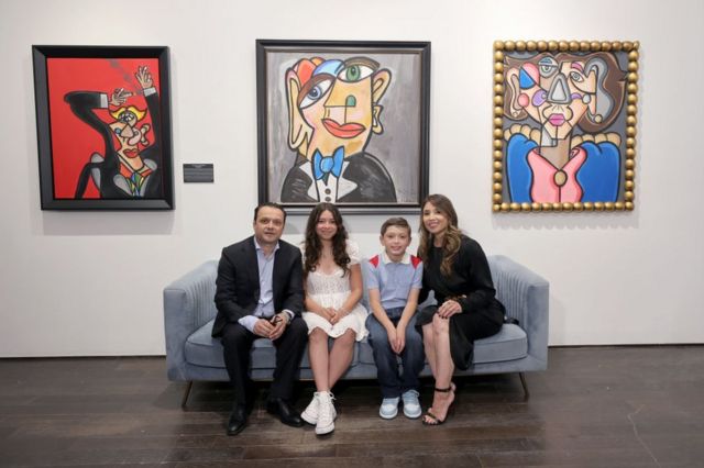 La familia Valencia (Andrés, su hermana Atiana, su madre Elsa y su padre Guadalupe) posa frente a tres cuadros de Andrés Valencia en la inauguración de su primera exposición individual, titulada "No Rules", en la galería Chase Contemporary de Nueva York, el 23 de junio de 2022.