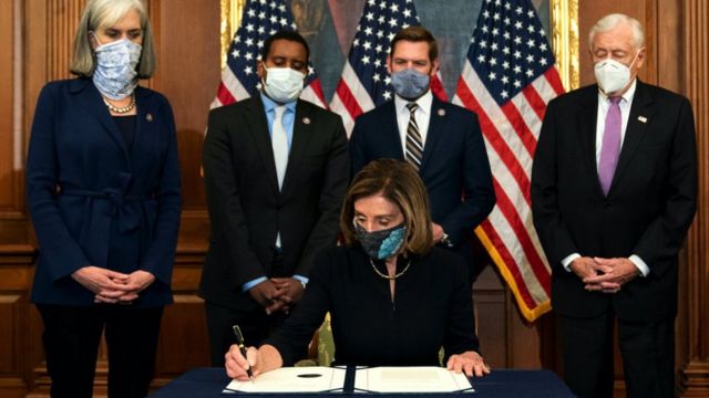 La présidente de la Chambre Nancy Pelosi (D-CA) (C) signe un article de destitution contre le président Donald Trump au Capitole américain le 13 janvier 2021 à Washington, DC.