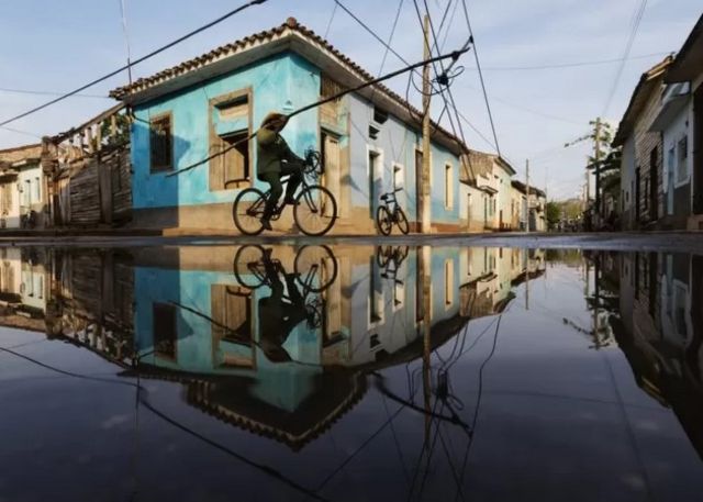 A man riding a bicycle in a flooded area