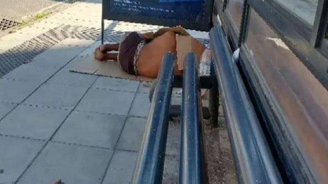Morador de rua deitado ao lado de banco cilíndrico instalado em Florianópolis