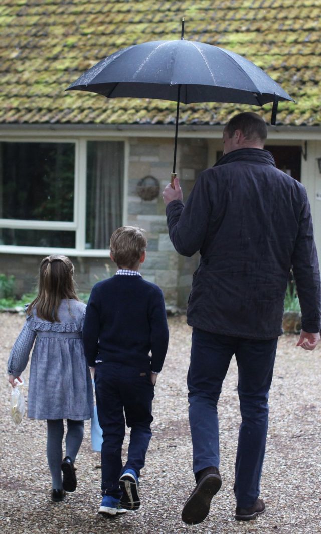 윌리엄 왕자가 아들 조지, 딸 샬럿에게 우산을 씌워주며 걷는 사진