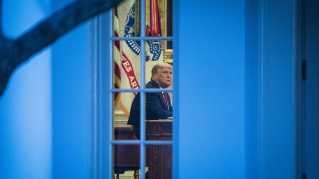 President Donald Trump talks with others in the Oval Office after speaking about 