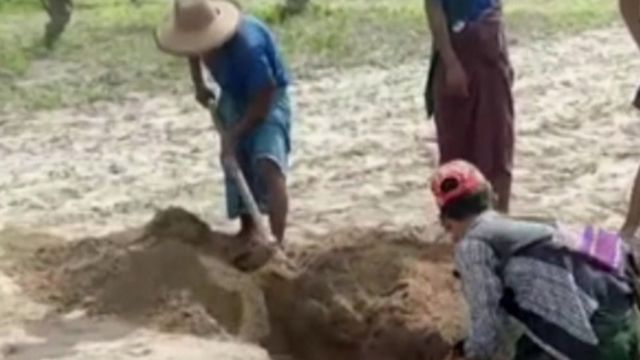 Homens cavam cova para enterrar vítimas dos massacres