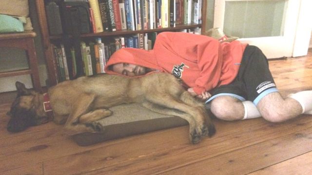 Dan dorme ao lado de seu cachorro
