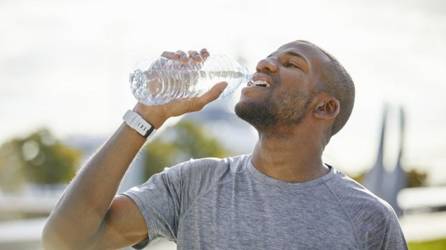 Hombre bebiendo agua.