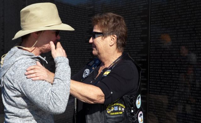 Starnes consuela a una visitante en el Vietnam Veterans Memorial, conocido como "la Pared de Vietnam", en Washington DC, Estados Unidos.
