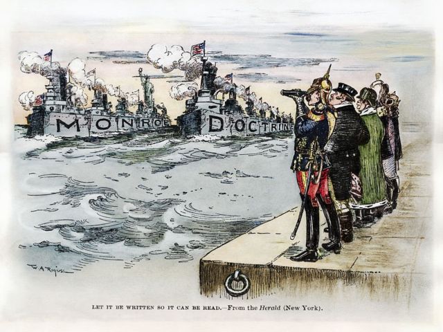 كاريكاتير نشر في صحيفة نيوورك هيرالد عام 1904 يظهر فيه حكام أوروبيون يرقبون عرضا لسفن حربية أمريكية كتب عليها "عقيدة مونرو"