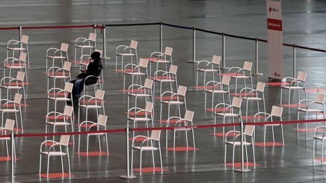 A person sits in the waiting area of a vaccination centre in Nuremberg, southern Germany