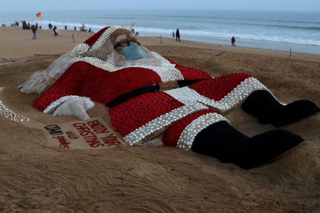 A giant sand sculpture of Santa Claus on the beach of Bay of Bengal in Odisha state, India. Photo: 24 December 2021