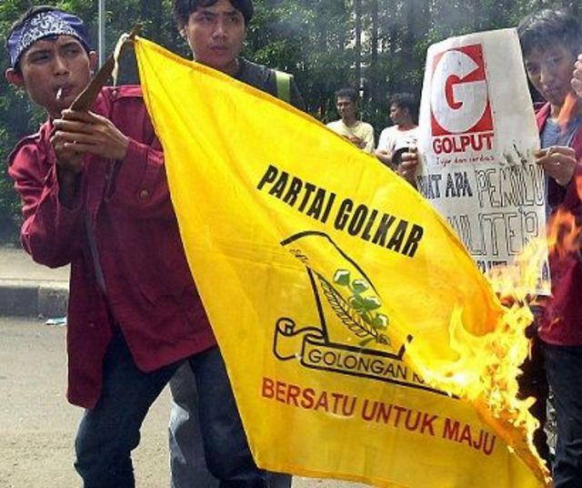 Mahasiswa membakar bendera partai Golkar di depan kampus di Jakarta pada 12 Januari 2004, saat memprotes politisi korup.