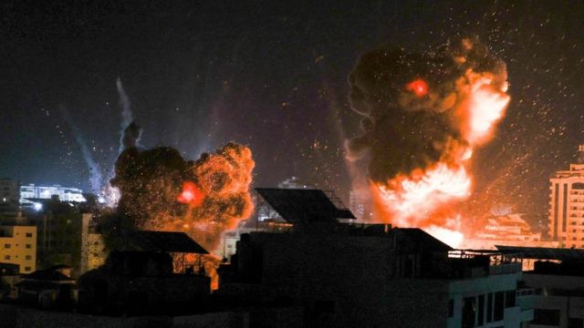 تضيء الانفجارات سماء الليل فوق المباني في مدينة غزة مع قصف القوات الإسرائيلية للقطاع، 18 مايو/أيار 2021