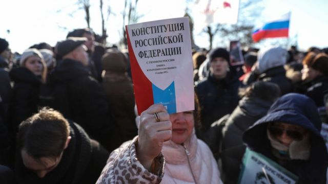 Женщина держит экземпляр Конституции России