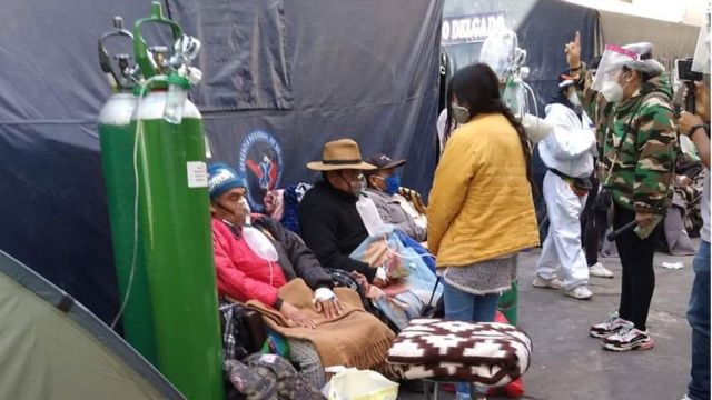 People line up in the street, with their own oxygen balloons