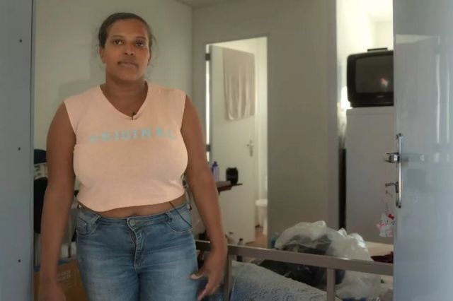 Mulher em p dentro da microcasa onde vive no Canind