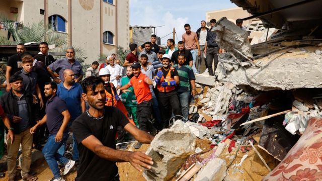 Palestinos inspecionam uma casa destruída em ataques israelenses em Khan Younis, no sul da Faixa de Gaza