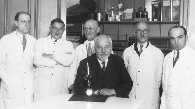 Albert Calmette junto a colegas frente a un microscopio