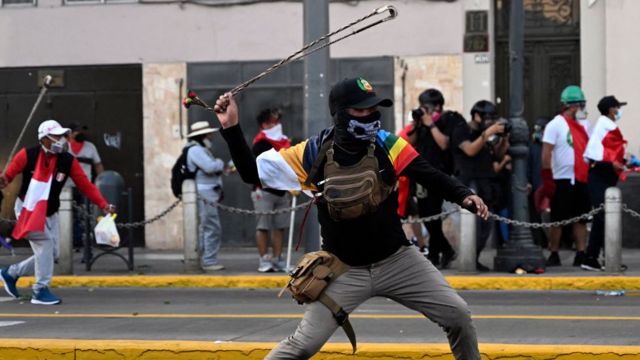 Manifestante ondea una onda en una protesta en Lima.
