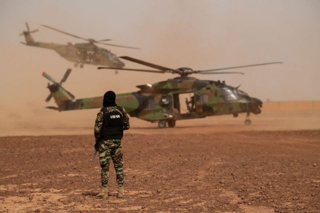 Um soldado da Unidade Especial de Intervenção Francesa ao lado de helicóptero no Níger
