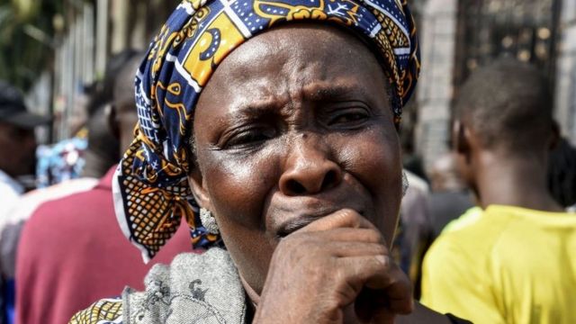 Un habitant pleure alors que des membres de l'église se rassemblent à l'entrée principale du siège de l'Église synagogue de toutes les nations (SCOA) pour pleurer le décès du pasteur nigérian TB Joshua, dans le quartier d'Ikotun à Lagos, le 6 juin 2021.