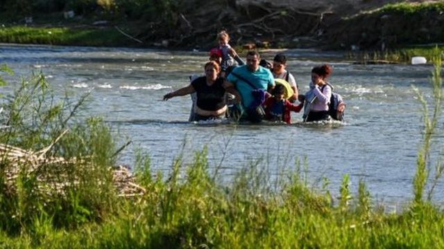 A family of Venezuelans cross the Rio Grande towards the United States