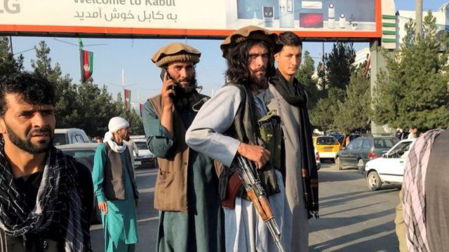 A member of Taliban (C) stands outside Hamid Karzai International Airport in Kabul, Afghanistan, August 16, 2021.