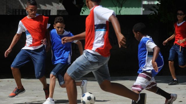 As crianças jogam futebol na escola