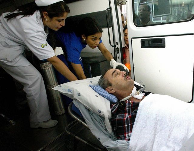 Luis Fernando Montoya es ayudado por enfermeras para entrar en una ambulancia